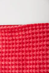 Neceser rojo con textura de tejido de toalla y cierre superior con cremallera.