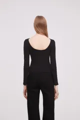 Remera blanca ajustada al cuerpo, de manga larga y cuello tipo bote.