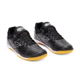 Championes deportivos Joma Maxima 2501 Indoor para fútbol sala, color negro con detalles en blanco y suela de goma color caramelo. Cuentan con refuerzo de goma en el calcetín mediante tecnología PROTECTION, mediasuela con amortiguación mejorada, suela de goma DURABILIDAD con alta resistencia a la abrasión y buen agarre en superficies internas, sistema de líneas FLEXO para una transición más natural, parte delantera de cuero sintético duradero y con buen contacto con el balón, perforación VTS para mejorar la ventilación del sudor y tecnología JOMA SPORTECH (TPU) sin costuras para un ajuste ceñido.