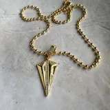 Collar dorado con cadena de bolitas y dije en forma de flecha con incrustaciones de strass.