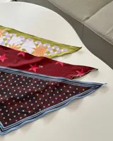 Pañuelo triangular estampado con diseño único dibujado a mano.