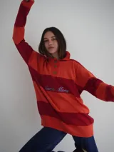 Sweater de hilo de algodón a rayas horizontales rosas y grises, con cuello polo, botones de guampa y bordado de Sierra Mora a tono.