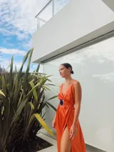 Vestido largo de satén color naranja, con escote en V, tajo lateral y cinturón con hebilla de alpaca y piedra ágata.