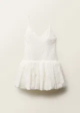 Vestido corto blanco con textura, tirantes finos y espalda abierta con lazo. Tiene escote de pico, cierre de cremallera en la parte posterior y corte globo.