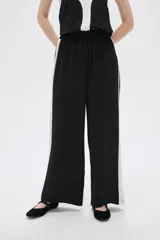 Pantalón ancho de poliéster negro con calce alto y detalle de color block blanco en los laterales.
