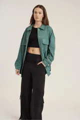 Pantalón de calce ancho y fluido en color negro, confeccionado en tejido de cupro. Presenta bolsillos laterales tipo cargo y un diseño de tiro alto.