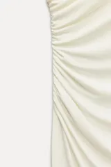 Vestido midi negro sin mangas, con cuello alto y detalle drapeado en el delantero. Cierre con cremallera oculta en la espalda.