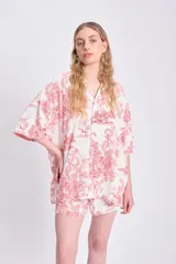Camisa de manga corta oversize de lino con estampado de palmeras y animales en color rojo sobre fondo blanco.
