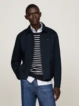Campera Tommy Hilfiger modelo Ivy, color azul marino, de corte regular, confeccionada en algodón. Tiene cuello inglés, cierre de cremallera, dos bolsillos diagonales en la cintura, puños con botón y logo bordado en el pecho.
