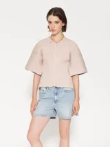 Short de tiro medio-alto en denim, con lavado claro y estampa serigráfica negra en el bolsillo trasero.