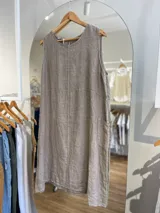 Vestido corto color beige de lino, con cuello redondo, sin mangas y bolsillos laterales.