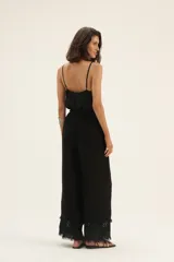 Pantalón negro de corte palazzo con cintura elastizada y cordón ajustable. Presenta detalle de bordado broderie en el ruedo.