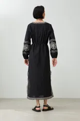 Túnica larga color crudo con bordados rojos en cuello, mangas y ruedo.