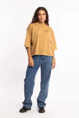 Remera blanca de corte cuadrado con cuello subido y mangas 3/4 amplias.