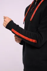 Canguro color crema con capucha, medio cierre engomado, bolsillo tipo canguro y detalle de franjas rojas en las mangas.