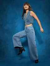 Pantalón de jean negro de tiro alto con corte ancho y pierna recta. Presenta costuras visibles y bolsillos tipo cinco bolsillos.