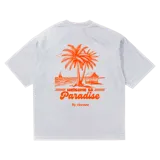 Remera blanca de algodón con estampado de palmeras y texto en color naranja.