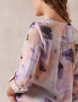 Blusa estampada con cuello a la base, escote en V y botones. Delantera con bolsillo aplicado. Largo de manga regulable con presilla y botón. Terminación anudada opcional.