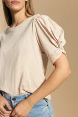 Remera negra de manga corta con mangas abullonadas y cuello redondo.