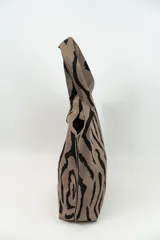 Bolso tipo tote con estampado animal print cebra en tonos marrón y negro.