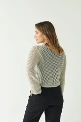 Sweater de punto calado color gris claro, de mangas largas y corte crop.