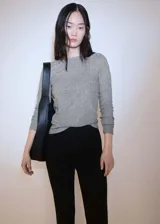 Camiseta gris de punto canalé con cuello barco y mangas largas. Diseño entallado.