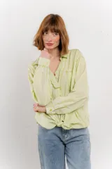 Camisa color crema de manga larga con cuello camisero y detalles de encaje en el escote. Se ata en la parte delantera.