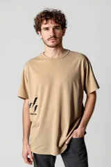 Remera color beige con estampado de rayos negros y texto en la parte inferior.