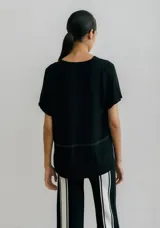 Remera blanca con corte horizontal y parte inferior negra. Cuello en V y mangas cortas.