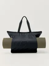Bolso tote negro multiusos con dos asas, tejido repelente al agua, cierre principal con cremallera, bolsillo exterior con cremallera y compartimento especial para transportar mat.