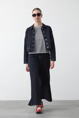 Remera de manga corta con cuello a la base, confeccionada en tejido de rayas horizontales blancas y negras, con silueta relajada.