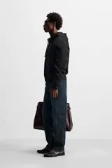 Jeans azul oscuro de corte recto, con largo al tobillo, confeccionados en denim de algodón con efecto lavado. Diseño de cinco bolsillos y cierre frontal con botones.