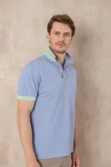 Chomba azul con cuello clásico, tapeta de dos botones y logo bordado en el pecho.