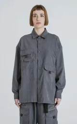Camisa de manga larga color grafito, estilo técnico con múltiples bolsillos delanteros con tapa y botones en cartera y puños. Presenta un calce oversize y está confeccionada en textil ligero y suave al tacto.