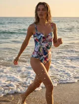 Malla enteriza estampada con motivos florales y de hojas, con breteles finos y escote con aplique metálico.