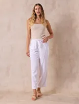 Pantalón largo de lino y rayón a rayas verticales grises y blancas. Tiene pretina elastizada con lazo de ajuste, bolsillos delanteros y traseros.