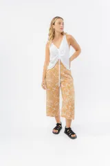 Pantalón culotte color ocre con estampado de hojas blancas, de tiro medio y corte recto.