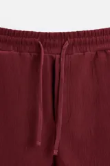 Bermuda negra de corte relaxed fit, con cintura elástica ajustable con cordón, bolsillos frontales y bolsillo trasero de parche.
