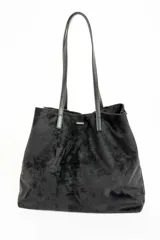 Bolso negro tipo tote bag confeccionado en gamuza vegana, con doble asa de hombro.