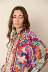 Camisa de mangas largas con cuello clásico y cierre frontal con botones. Estampado multicolor con motivos florales y geométricos.