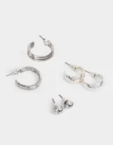 Set de aros plateados con pasante, que incluye aros tipo botón con diseño de nudo y aros tipo argolla de diferentes tamaños.