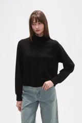 Buzo negro de manga larga con cuello tortuga y corte holgado.