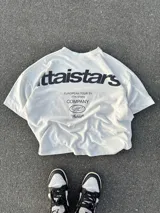 Remera negra de algodón con estampado blanco en la espalda con el logo de la marca y la frase "European Tour by Ittai Stars Company".