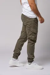 Pantalón cargo color beige de gabardina, con corte ajustado, bolsillos laterales con fuelle y puños elásticos en los tobillos.
