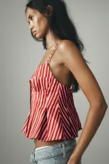 Top con estampado a rayas verticales rojas y blancas, escote pico, tirantes finos ajustables, detalle de pliegues y cierre frontal con botones.