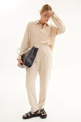Pantalón de lino color beige, con cintura elastizada y cordón ajustable.
