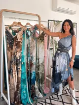 Vestido largo de tela fluida, color verde esmeralda con estampado abstracto en tonos turquesa y detalles dorados. Diseño asimétrico con un solo tirante tejido en el hombro.