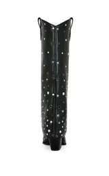 Bota de caña alta de cuero sintético negro con diseño plegable y tachuelas circulares plateadas. Tiene punta puntiaguda y tacón grueso.