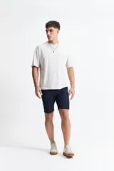 Bermuda de gabardina azul marino, corte chino clásico, con pasacintos y logo bordado. Colección SS 26.