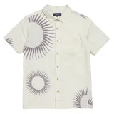Camisa de manga corta color crema con estampado de soles en color gris. Tiene cuello clásico, cierre con botones y un bolsillo en el pecho.